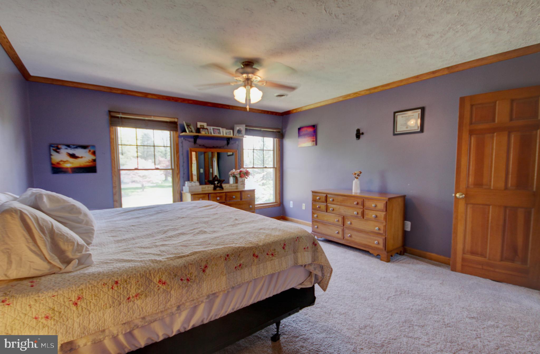 215 Hoffecker Road Phoenixville, PA 19460 - Photo 32 of 49 a bedroom with a large bed a chandelier and dresser