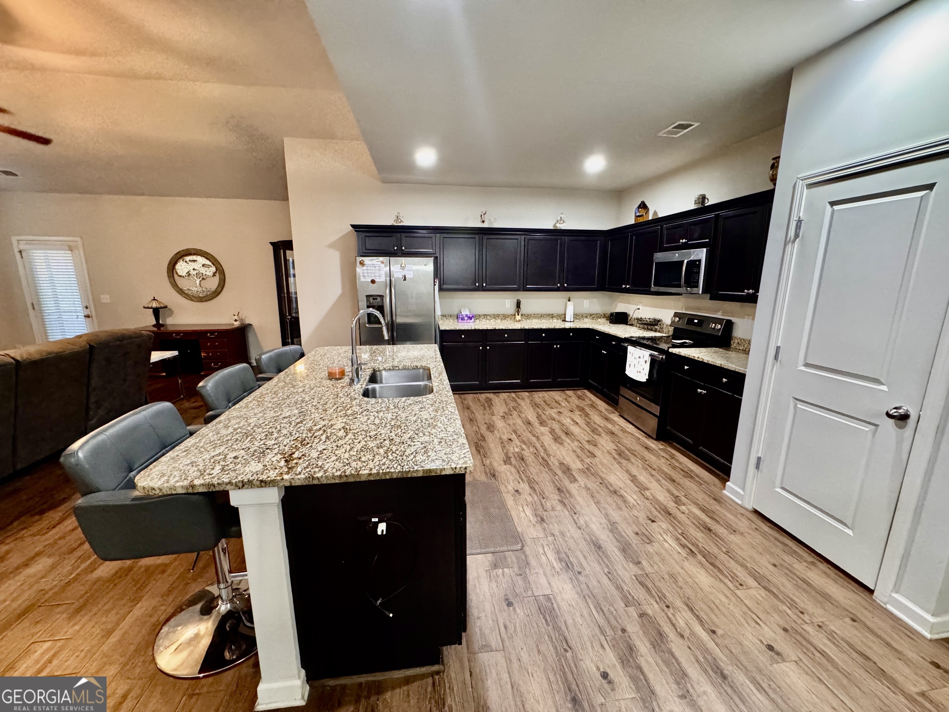 52 Pulaski Avenue Hampton, GA 30228 - Photo 13 of 32 a kitchen with a sink a stove a refrigerator and cabinets