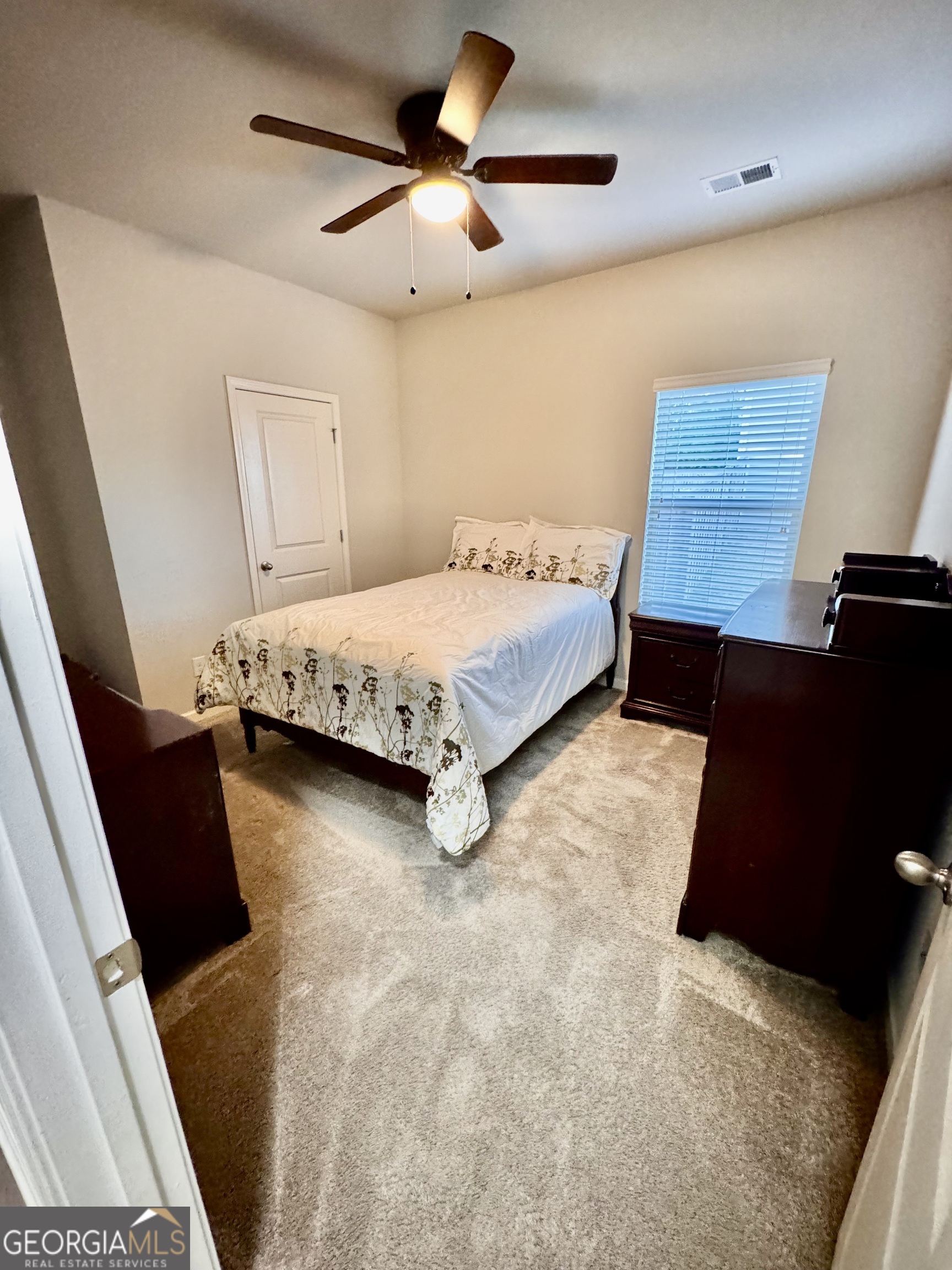 52 Pulaski Avenue Hampton, GA 30228 - Photo 21 of 32 a bedroom with a bed and a flat tv screen on the dresser