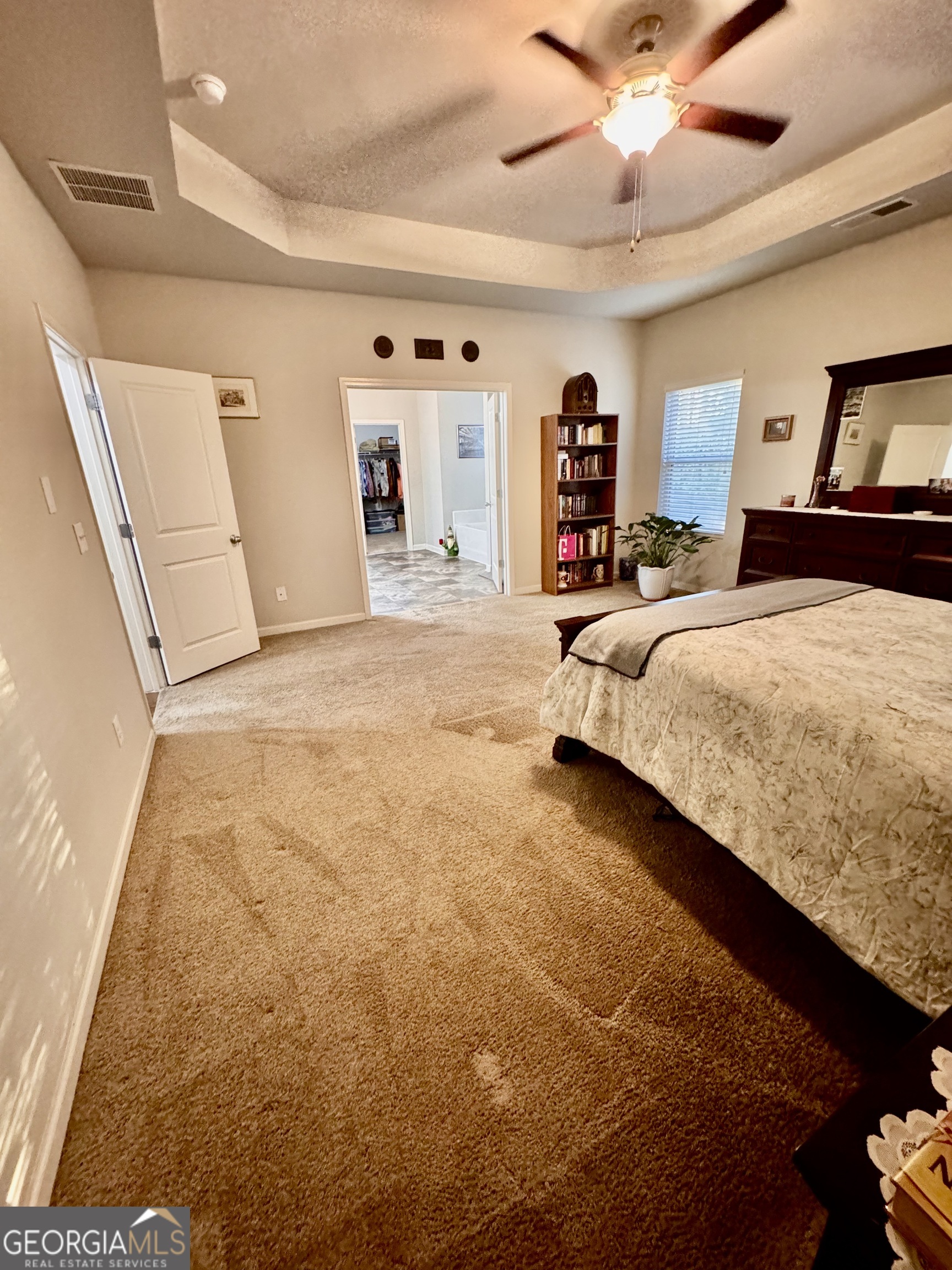 52 Pulaski Avenue Hampton, GA 30228 - Photo 24 of 32 a bedroom with a large bed and a flat tv screen on dresser