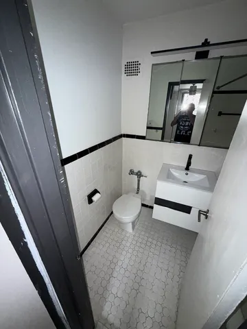 a bathroom with a sink toilet and mirror