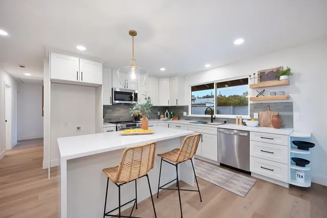 a kitchen with stainless steel appliances white cabinets and a sink