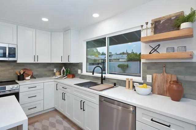 a kitchen with a sink a counter space and living room
