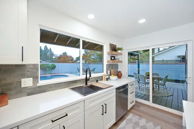 a living room with furniture a large window and a wooden floor