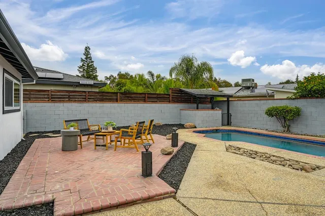 a view of a house with swimming pool and sitting area
