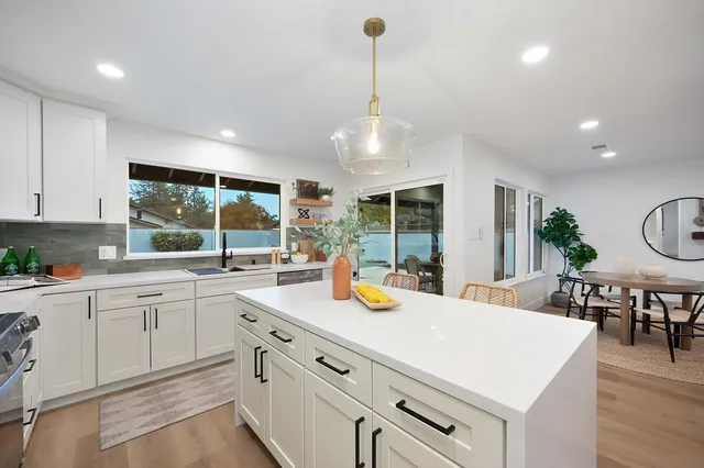 a kitchen with a sink a stove a counter space and cabinets