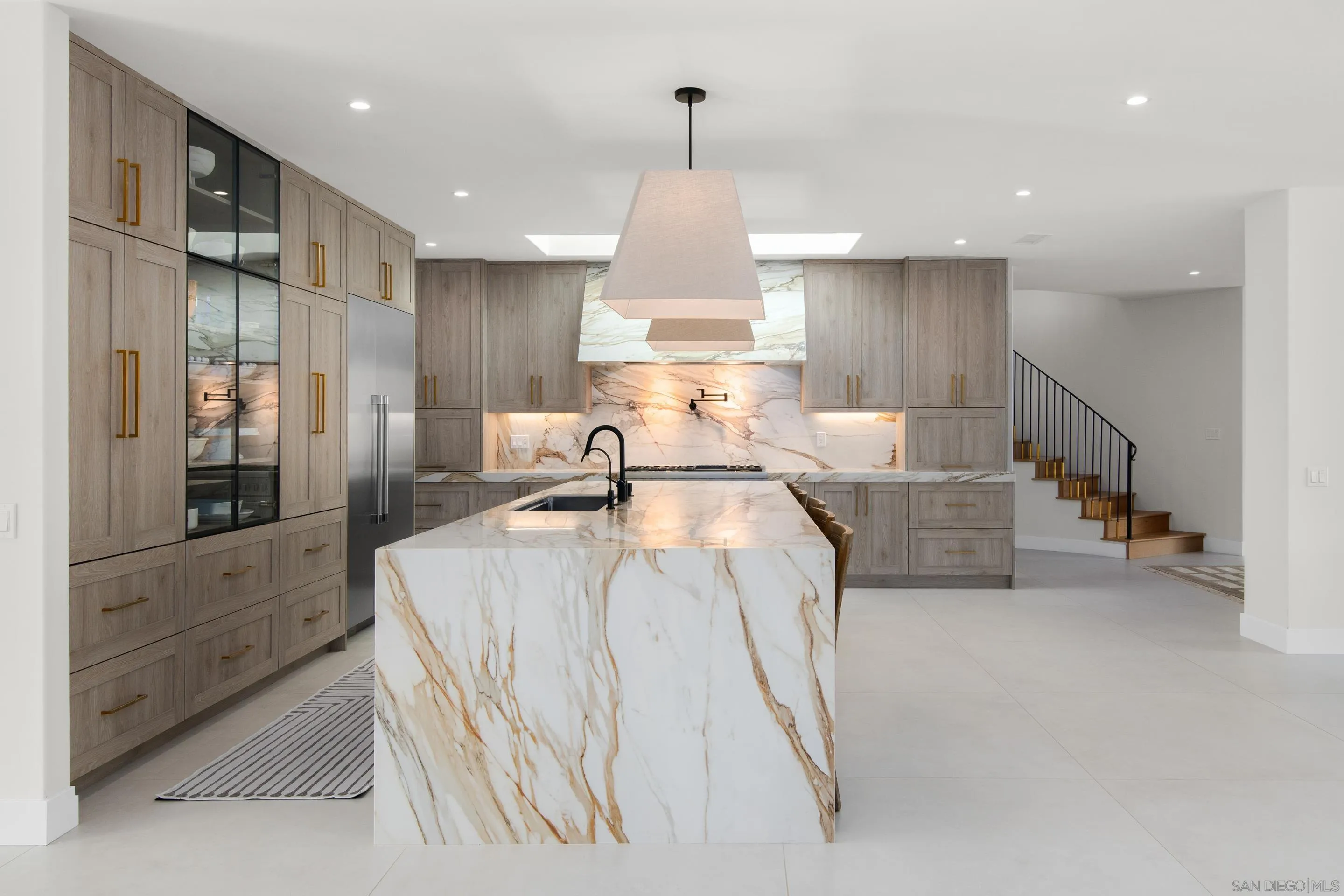 6665 Via Estrada La Jolla, CA 92037 - Photo 15 of 59 a large white kitchen with kitchen island a large counter top space a sink stainless steel appliances and cabinets
