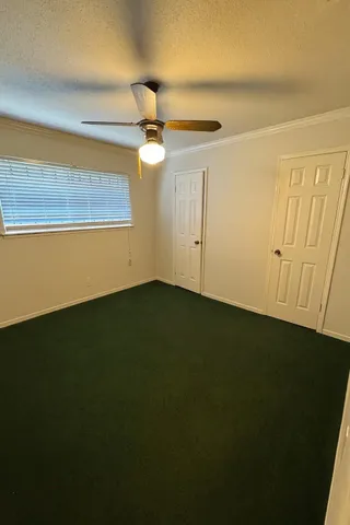 a view of empty room with ceiling fan and window