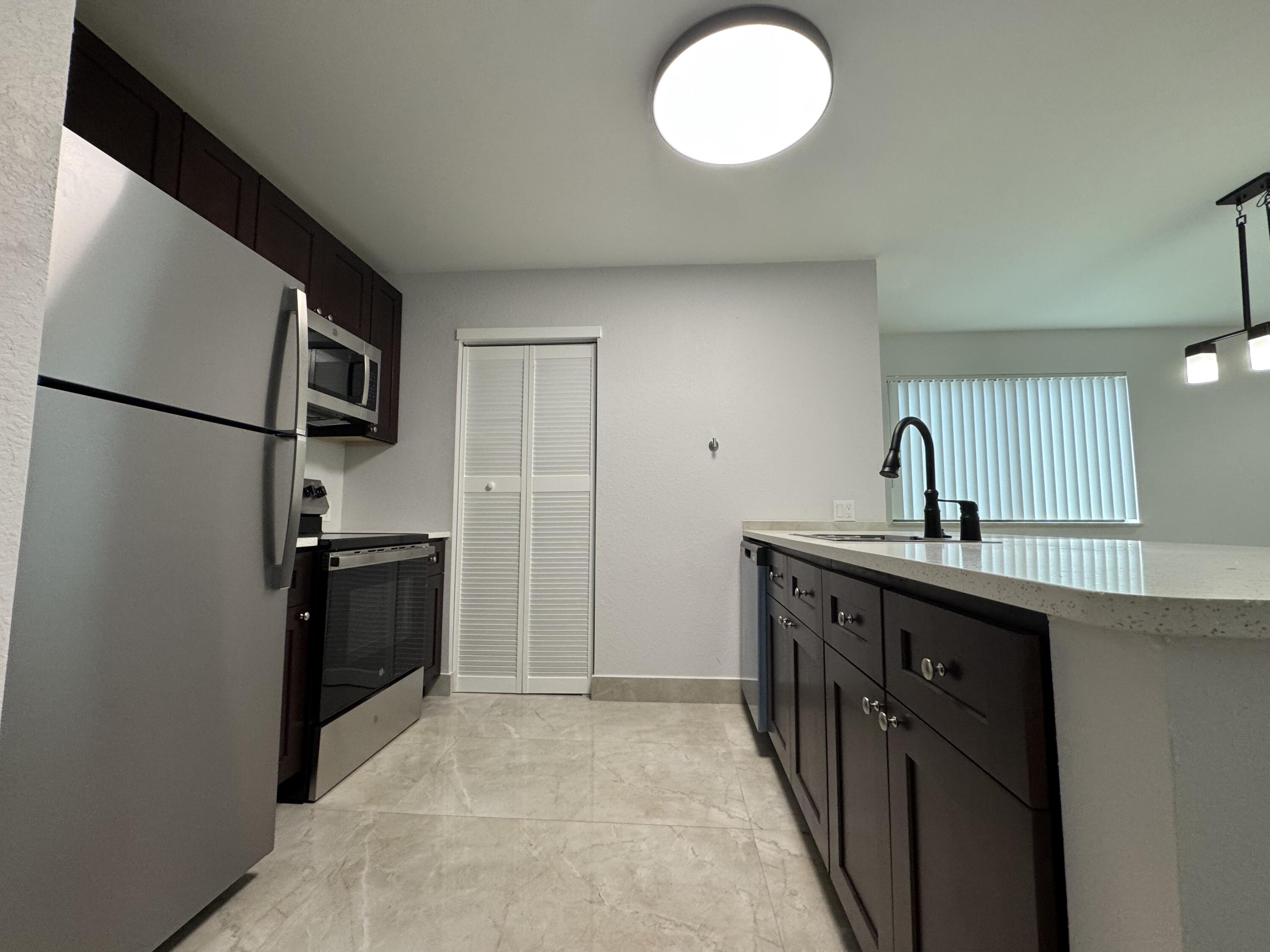 400 Northeast 30th Street, Unit 2 Pompano Beach, FL 33064 - Photo 17 of 22 a kitchen with stainless steel appliances a refrigerator and a sink
