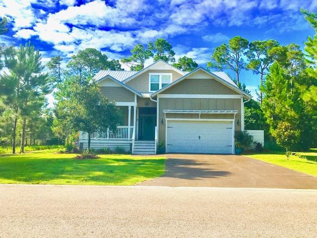 153 Spotted Dolphin Road Santa Rosa Beach, FL 32459 - Photo 1 of 36 a front view of a house with a yard and garage