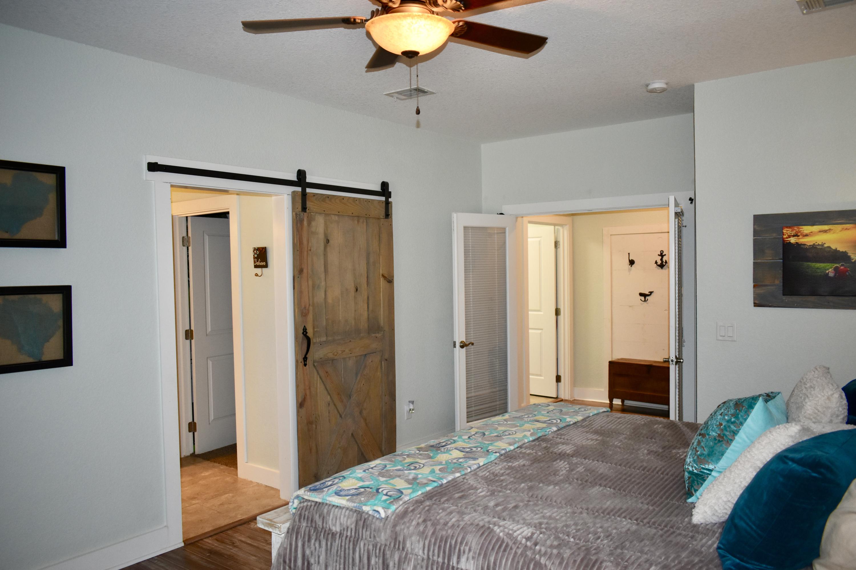 153 Spotted Dolphin Road Santa Rosa Beach, FL 32459 - Photo 22 of 36 a bedroom with a bed and a chandelier