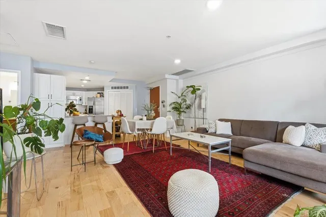 a living room with lots of furniture wooden floor and a rug