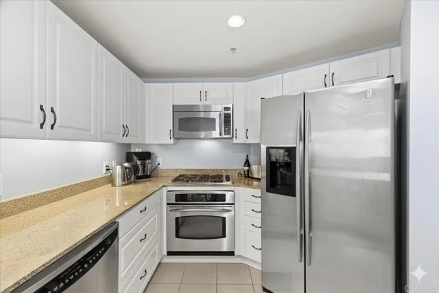 a kitchen with cabinets stainless steel appliances and a counter space