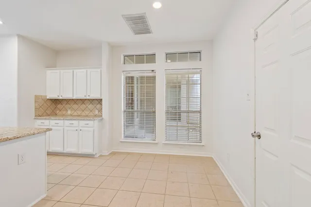 a kitchen with granite countertop white cabinets and stainless steel appliances