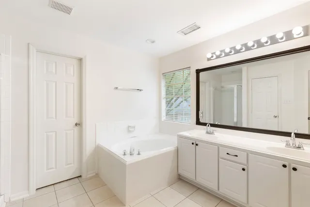 a bathroom with a granite countertop sink and a bathtub