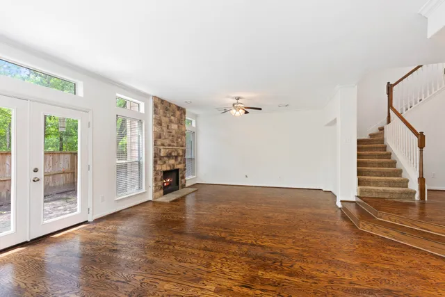 a view of a livingroom with wooden floor and a ceiling fan