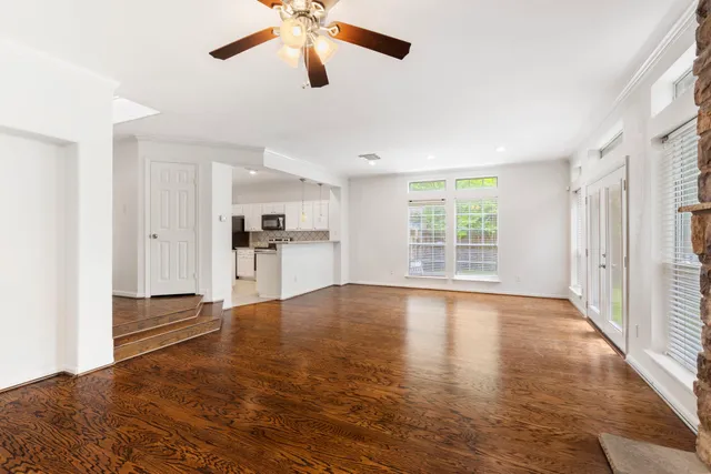 a view of empty room with wooden floor and window