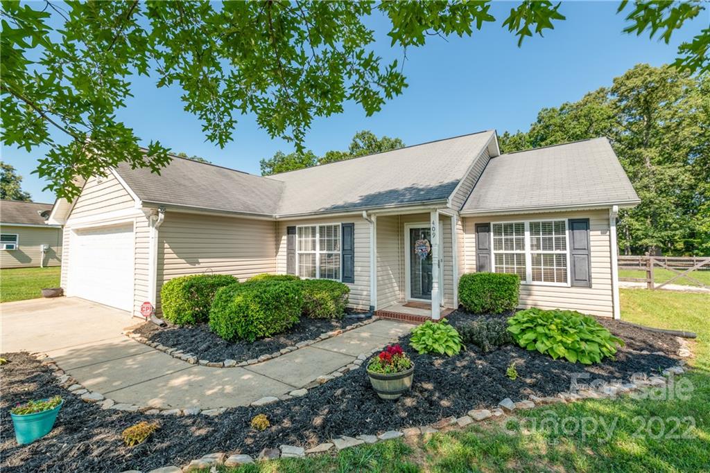409 Funderburk Road Wingate, NC 28174 - Photo 3 of 22 a front view of a house with a garden and plants
