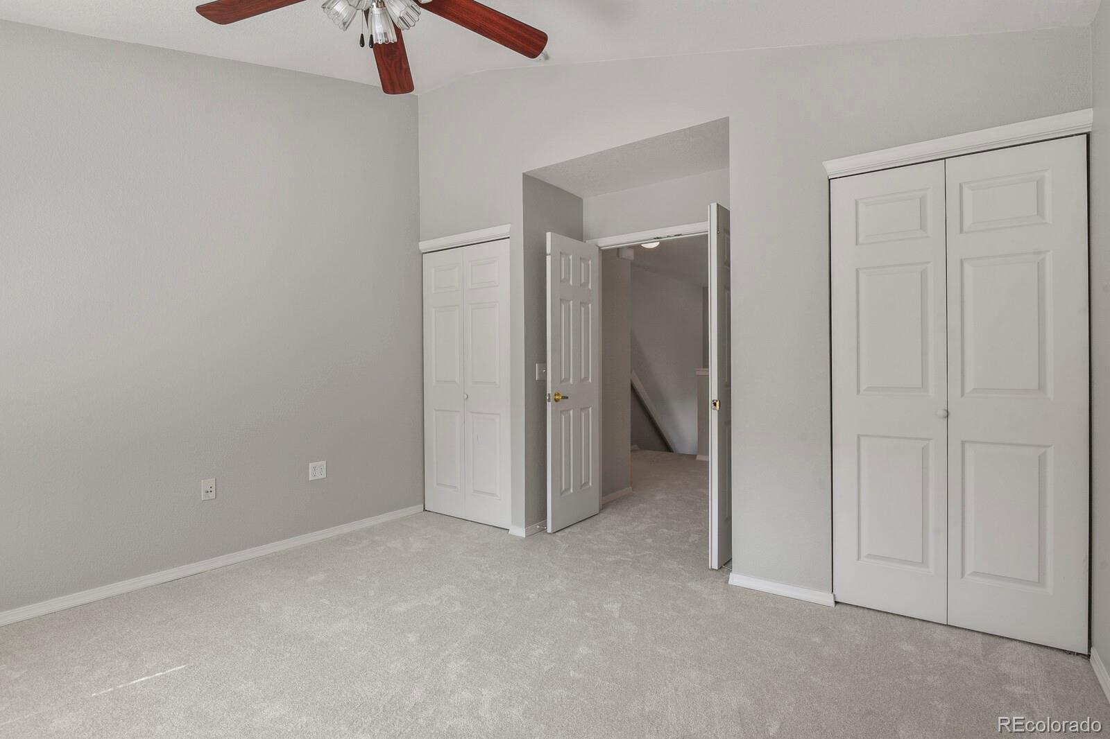 6444 Silver Mesa Drive, Unit A Highlands Ranch, CO 80130 - Photo 18 of 40 an empty room with a hallway and a chandelier fan