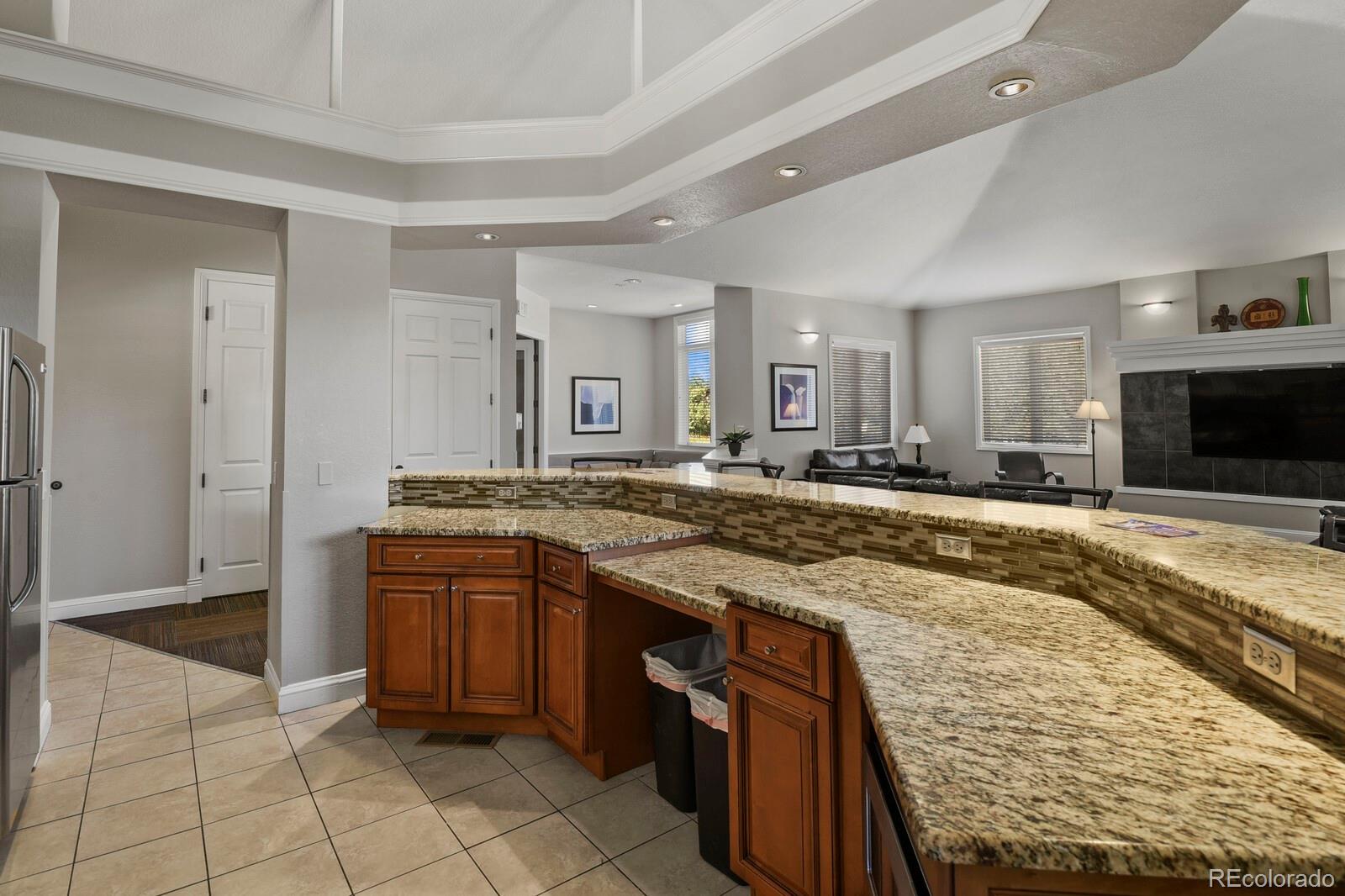 6444 Silver Mesa Drive, Unit A Highlands Ranch, CO 80130 - Photo 32 of 40 a large kitchen with kitchen island granite countertop a sink and cabinets
