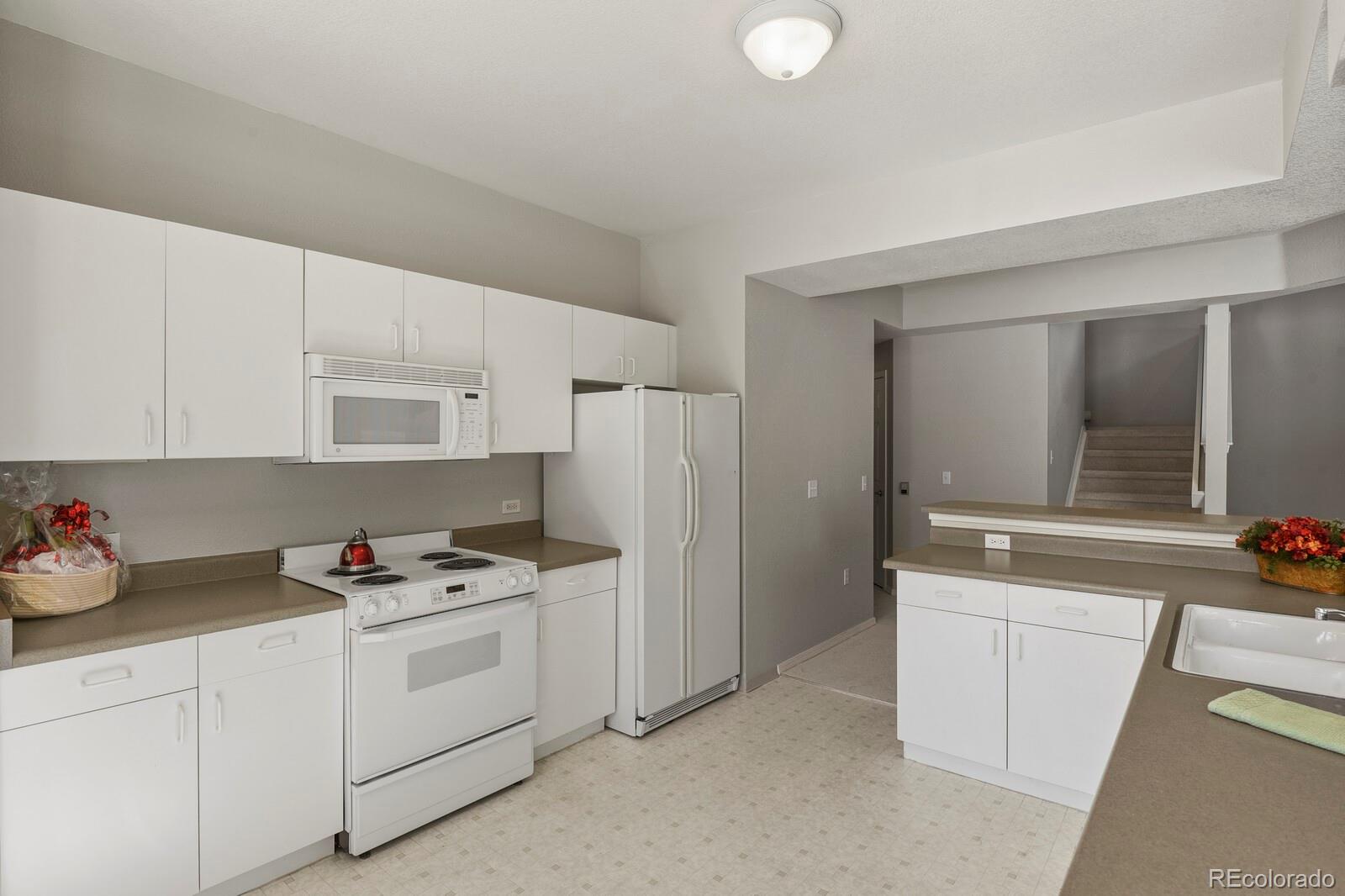 6444 Silver Mesa Drive, Unit A Highlands Ranch, CO 80130 - Photo 9 of 40 a kitchen with cabinets and appliances