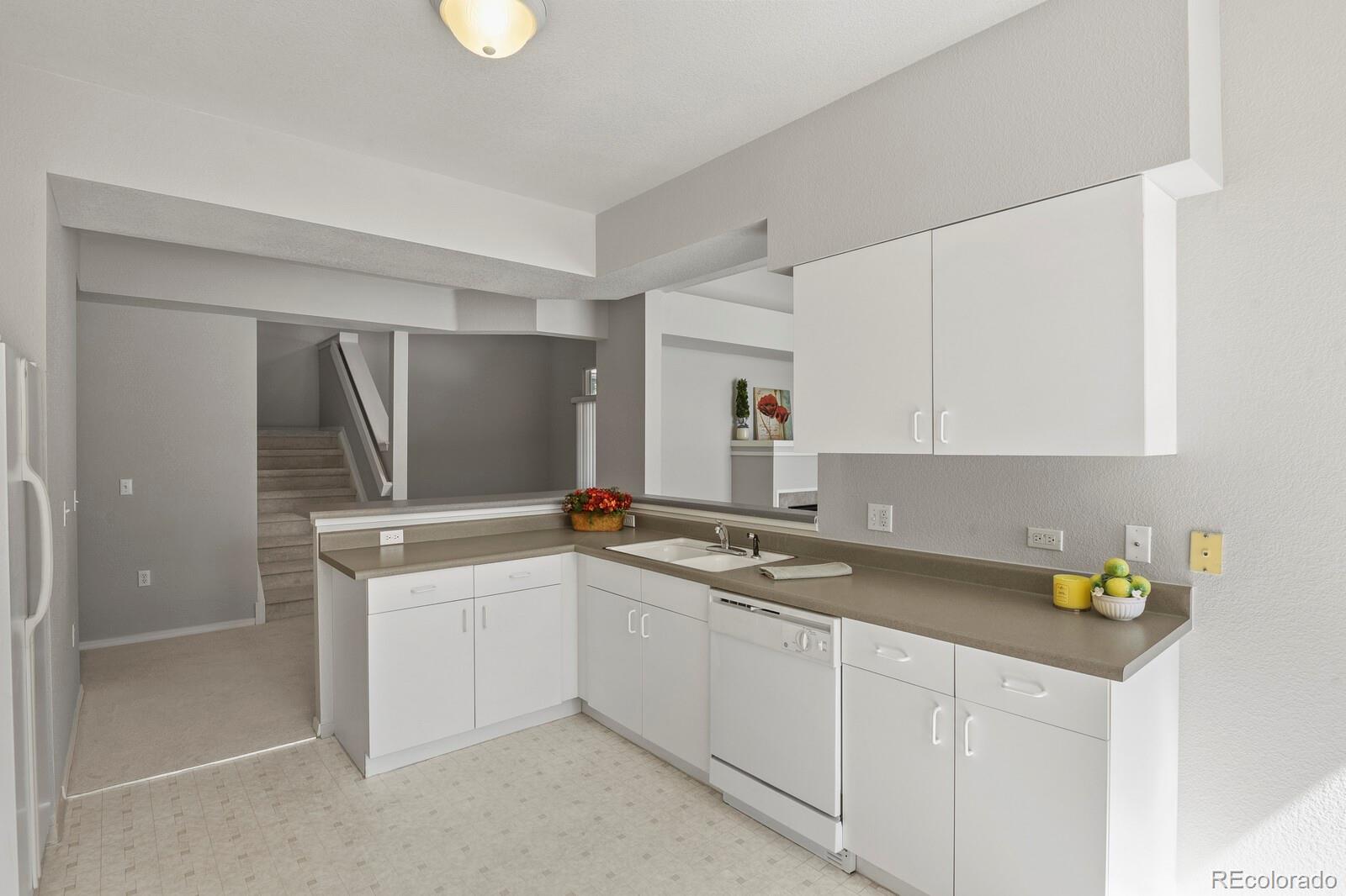 6444 Silver Mesa Drive, Unit A Highlands Ranch, CO 80130 - Photo 10 of 40 a kitchen with a sink a stove and cabinets