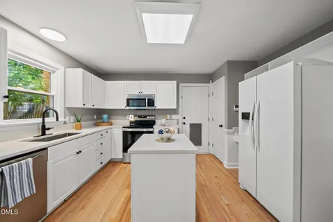 a kitchen with a table chairs refrigerator and cabinets