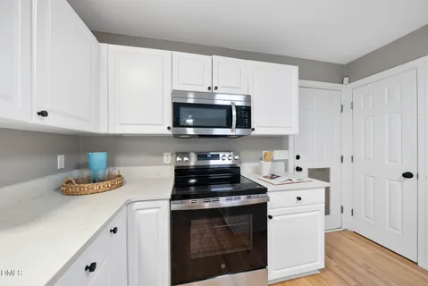 a kitchen with a sink cabinets appliances and a window
