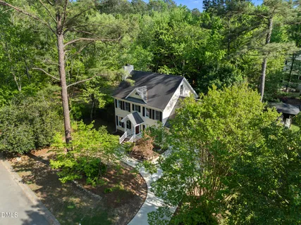 a front view of a house with a yard and lake view