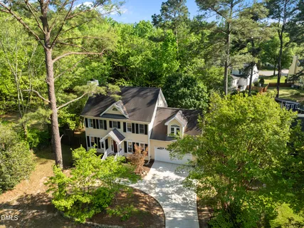 an aerial view of residential houses with outdoor space and trees