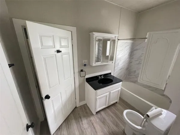 a bathroom with a sink a toilet a mirror and shower