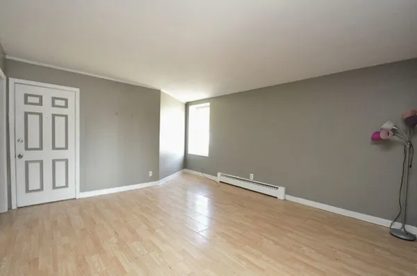 a view of an empty room with wooden floor