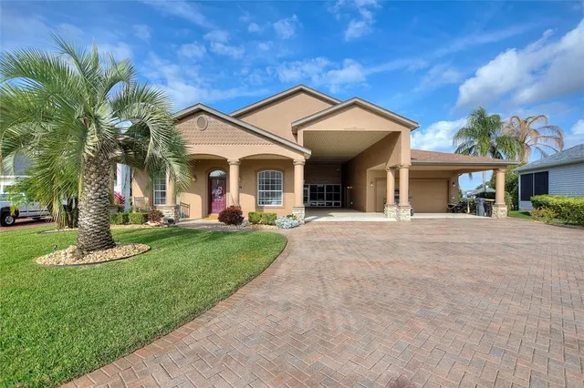 a view of a white house with a big yard and palm trees