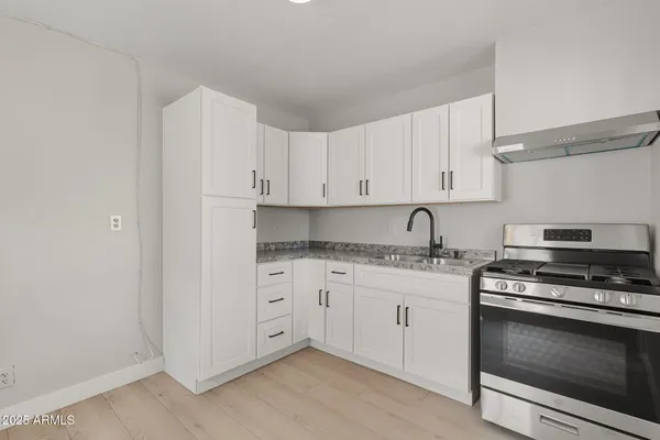 a kitchen with granite countertop white cabinets and stainless steel appliances