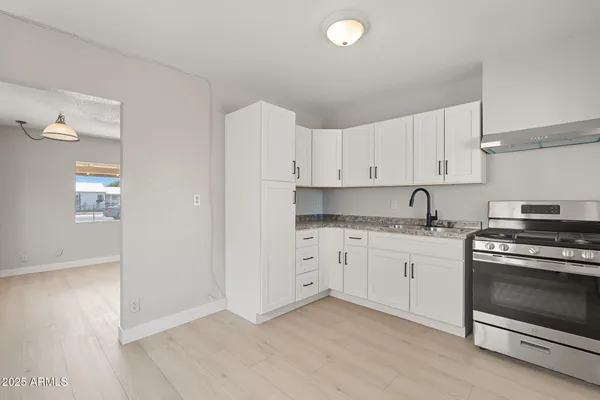 a kitchen with granite countertop white cabinets and white appliances