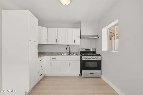 a kitchen with granite countertop white cabinets and stainless steel appliances