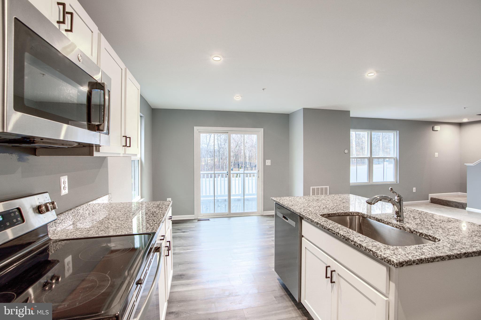 104 Magnolia Drive Elkton, MD 21921 - Photo 13 of 52 a kitchen with stainless steel appliances granite countertop a sink a stove and a microwave