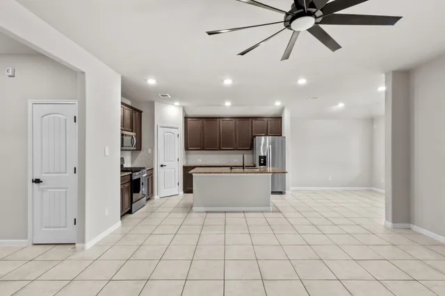 a view of kitchen with stainless steel appliances kitchen island granite countertop a refrigerator oven a sink and dishwasher