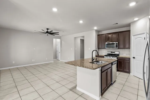 a kitchen with stainless steel appliances granite countertop a sink stove and refrigerator