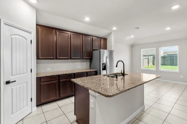 a kitchen with granite countertop a sink and cabinets