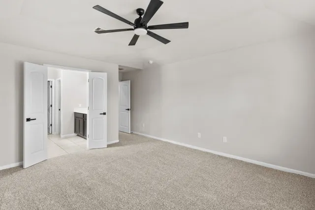 an empty room with closet and a ceiling fan