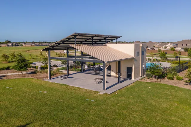 a view of a patio with table and chairs under an umbrella