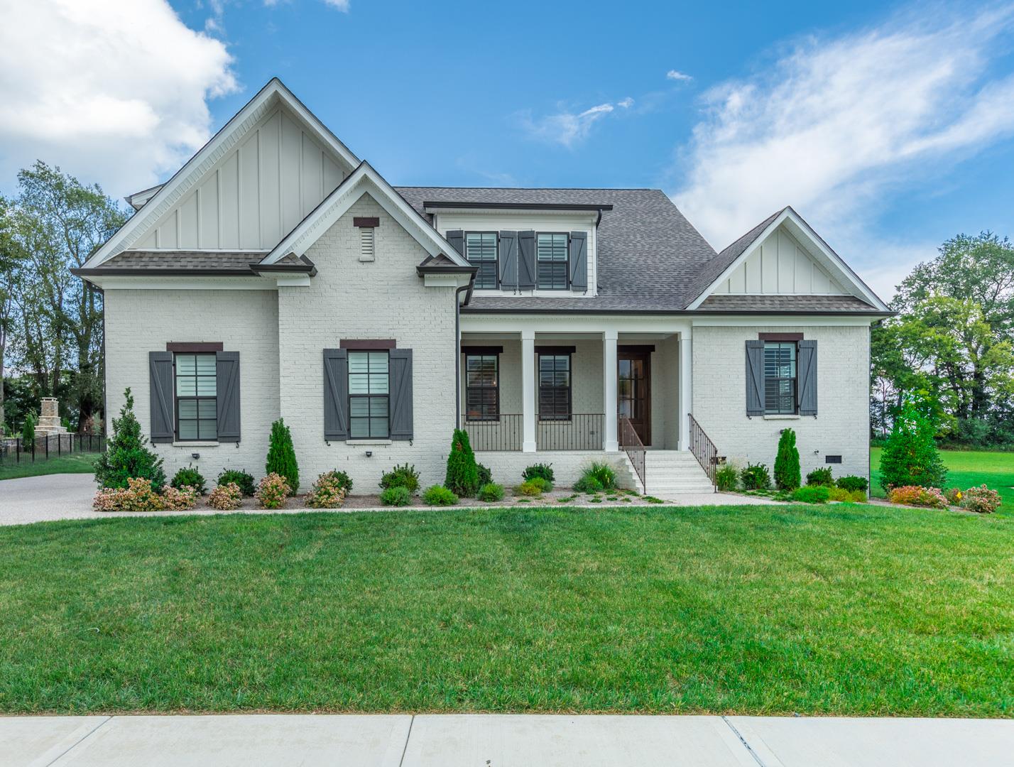 a front view of a house with a yard and plants