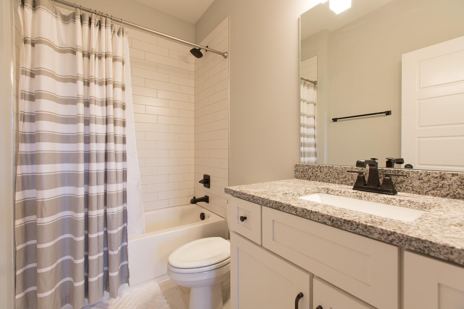 4119 Old Light Circle Arrington, TN 37014 - Photo 24 of 25 a bathroom with a granite countertop sink toilet and shower