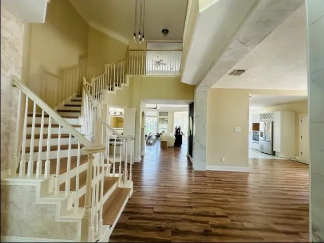 a view of a hallway with wooden floor and staircase