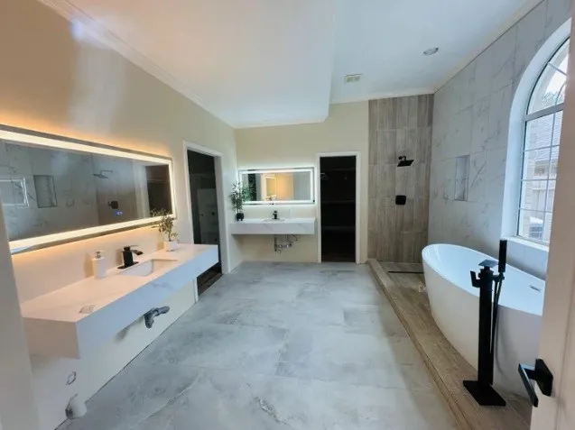 a bathroom with a tub sink and mirror