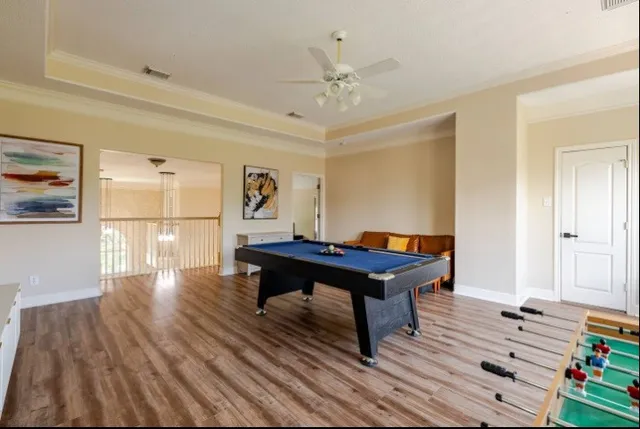 a room with furniture pool table and wooden floor