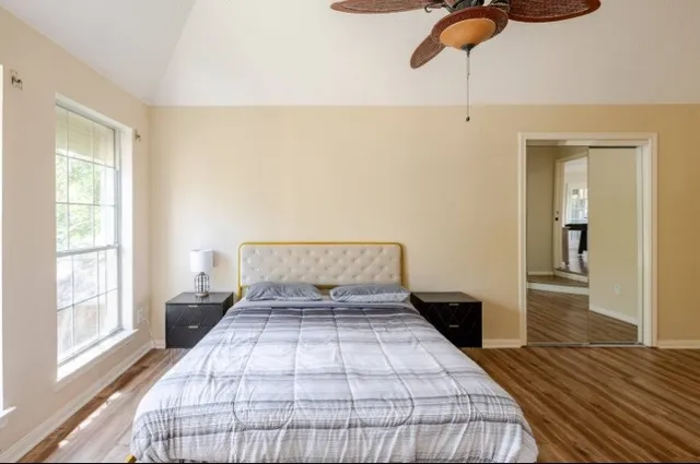 a bedroom with a large bed and wooden floor