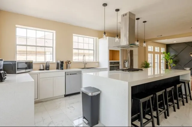 a kitchen with cabinets and chairs