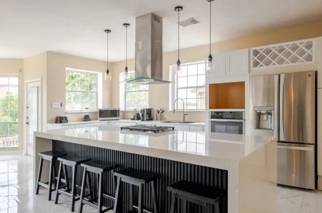 a kitchen with stainless steel appliances granite countertop a sink a stove and a refrigerator
